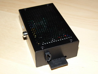 Mikropočítač Raspberry Pi v krabičce EM-RASPBERRY B+(Black) společnosti EMKO.cz s doplněným DC/DC zdrojem RASP-PSM. Vedle slotu paměťové SD karty přibyl napájecí konektor zdroje RASP-PSM
